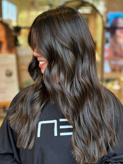 A side profile showcasing the beautiful blend of colors in this balayage. The transition from her natural base to the lighter ends is completely seamless.