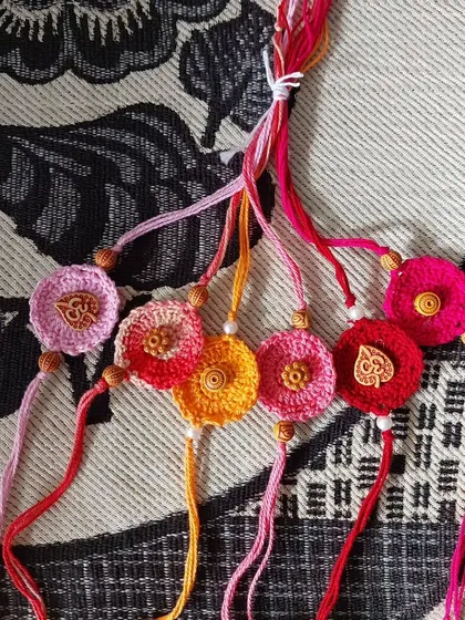 A collection of custom crochet rakhis I made, featuring Om symbols and floral designs.