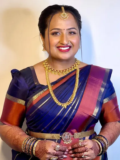 A smiling portrait of Supritha during her Varpooja. The makeup is radiant and festive, perfect for this important pre-wedding ritual.