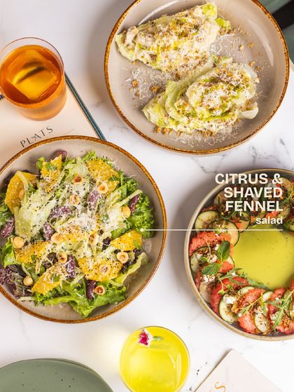 Highlighting our Citrus & Shaved Fennel salad, a refreshing mix of greens, orange segments, olives, and toasted hazelnuts.