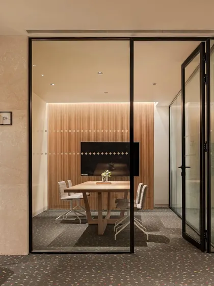 The glass-enclosed business center at the Elevate Clubhouse offers a quiet space for work while maintaining a visual connection to the vibrant social areas, reflecting the modern need for flexible living.