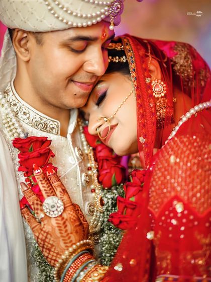 An intimate and emotional close-up of the couple. The bride rests her head on the groom's chest, a picture of love, trust, and comfort.