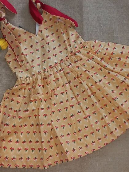 A closer look at another one of my handpicked fabric frocks. This one has a sweet floral print on a yellow base with contrasting red ties, showing how I love to mix and match prints and colors.