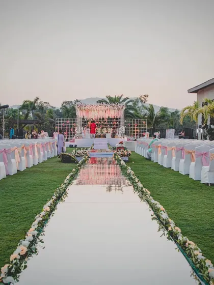 The stunning mirror aisle reflecting the sky and the floral mandap at this outdoor wedding in Karjat. We use reflective surfaces to add a layer of magic to the decor.