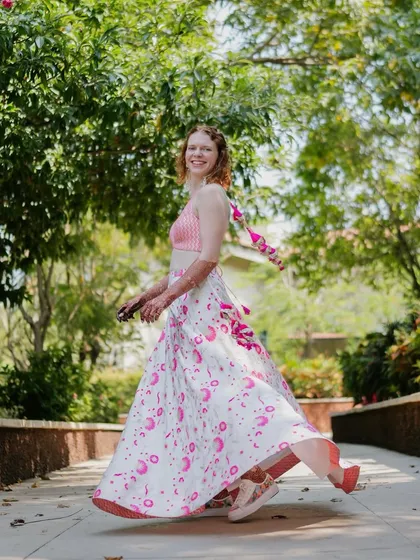 The bride gives a twirl, showing off her breezy, custom-made lehenga skirt. This outfit was designed to be comfortable and stylish for welcoming their guests to Goa.