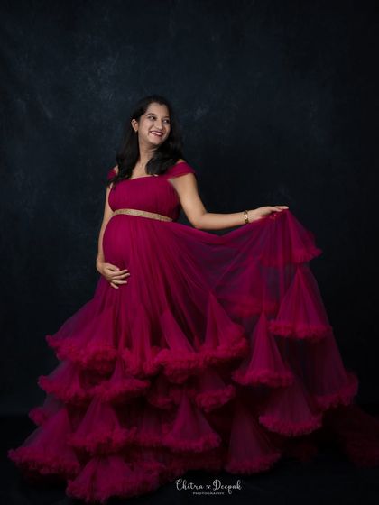 A playful twirl in a magenta tiered gown. We love capturing the joy and movement that brings a maternity portrait to life.