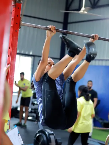A close-up action shot of an athlete executing a toes-to-bar with focus and determination during The Bengaluru Throwdown.