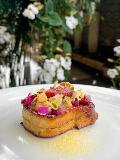 Another view of the Pain Perdu, set against a natural backdrop. The colors of the fruit and edible flowers make it a truly beautiful dish.