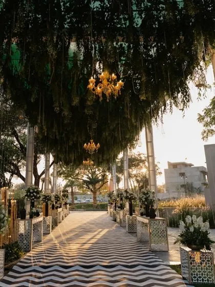 The guest experience begins the moment they arrive. We create grand, immersive entrances like this one, using lush greenery, elegant chandeliers, and a striking patterned walkway to build anticipation and make a powerful first impression for your conference or corporate retreat.