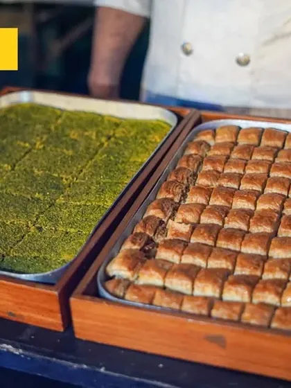 We transport you to the heart of authentic Turkish cuisines. This image shows trays of freshly made Baklava and other pistachio-based sweets, offering a taste of traditional Turkish desserts.