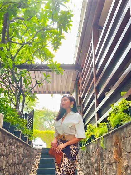 The linen skirt outfit in a beautiful, green outdoor setting. The natural materials of the outfit feel right at home here.