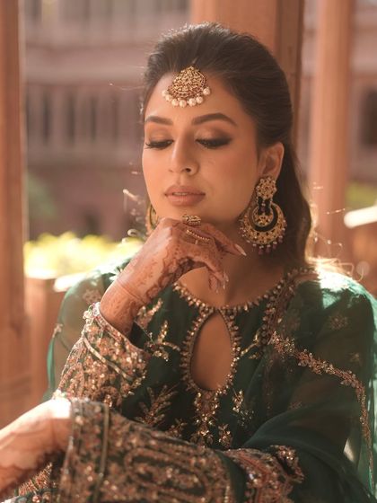 A pensive moment, showcasing the soft, golden-toned eyeshadow and the flawless base. This look is both traditional and modern.