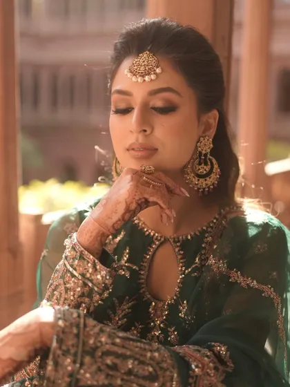 A pensive moment, showcasing the soft, golden-toned eyeshadow and the flawless base. This look is both traditional and modern.