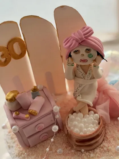 A close-up of the spa day cake topper. I had so much fun sculpting the tiny details, like the face mask and the little bottles of lotion.