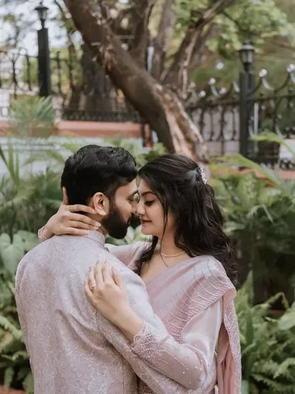 An intimate embrace in a garden setting. This photo captures a quiet, romantic moment away from the crowds, focusing on the couple's connection.