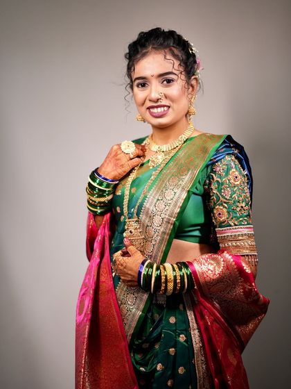 A full view of the bride's green Nauvari look against a simple background, making her outfit pop.