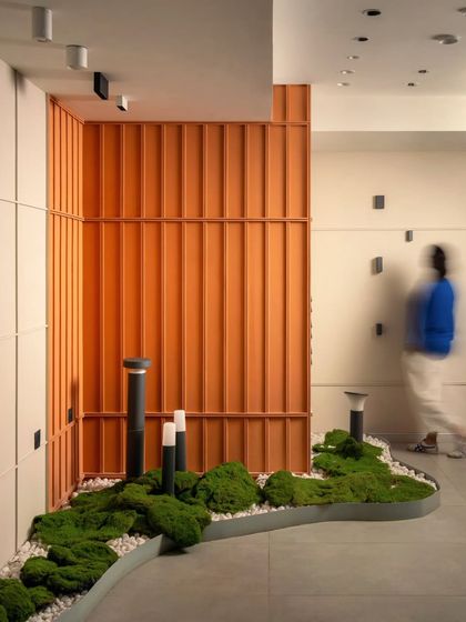 Another perspective of the moss installation and orange accent wall. This composition highlights the dynamic lines and varied textures we used to create a visually engaging showroom.