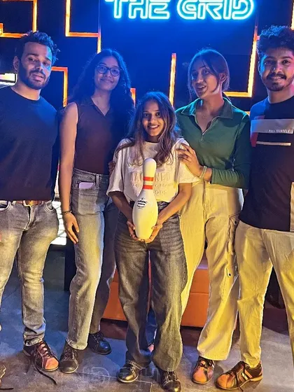 A duplicate of image 101, with friends posing with a bowling pin.