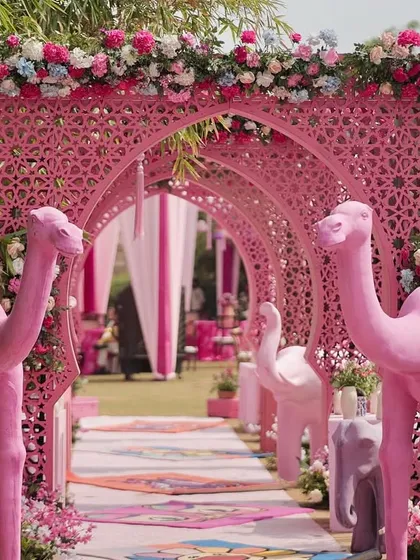 Your entrance should tell a story. For this Rajasthani-themed Mehendi in Jaipur, I created a whimsical pathway lined with life-sized pink camels and intricate jaali arches, making for a vibrant and picture-perfect welcome.