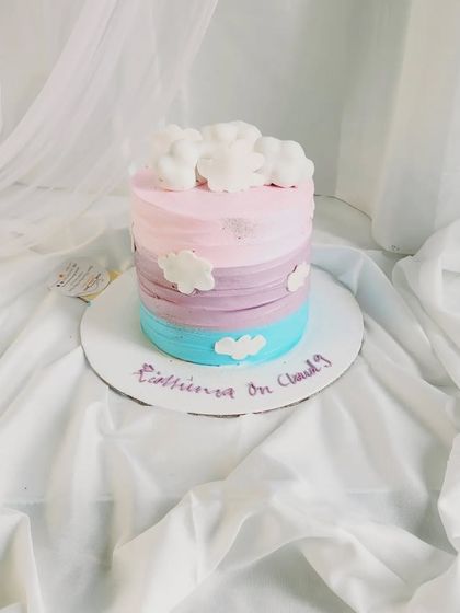 A full view of our "on cloud 9" rainbow cake, showing the soft pastel colors and dreamy cloud decorations.