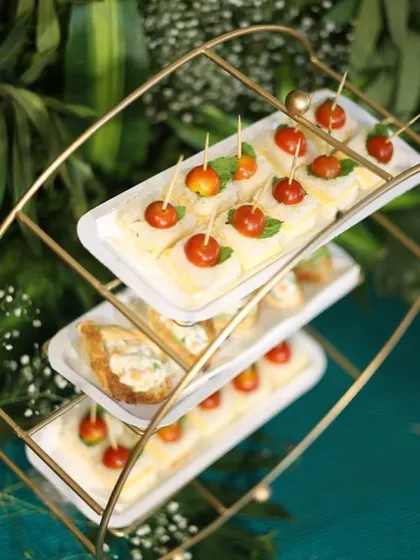 A three-tiered stand showcasing our mini sandwiches. They are perfect for high tea, bridal showers, or any event where you want to serve light and elegant snacks.