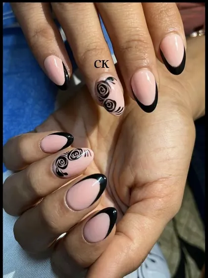 A sophisticated black French manicure with hand-painted black rose accent nails.