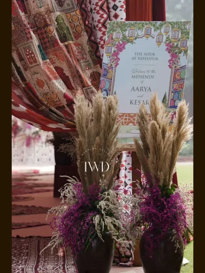 The welcome signage for the 'Souk at Fatehpur' Mehendi, framed by pampas grass and rich fabrics, setting the tone for the event.