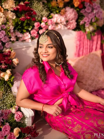The bride looking radiant on her floral throne during the Mehendi ceremony.