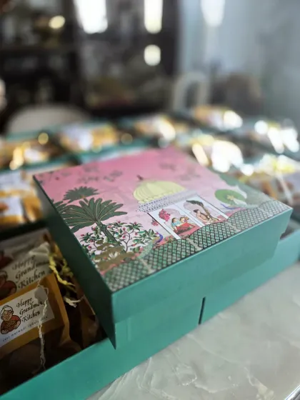 We believe a gift should feel special from the moment you see it. This is a close-up of one of our decorative gift boxes, featuring beautiful traditional artwork. Inside, each snack is carefully packed to ensure it arrives fresh and full of flavour, ready to be enjoyed.