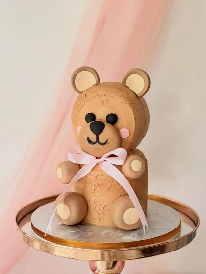 This fully sculpted 3D teddy bear cake is as delicious as it is cute. I shaped the layered cake and used textured buttercream to create the fur, finishing it with a simple pink bow. It's a perfect example of how a cake can be both a sculpture and a treat.