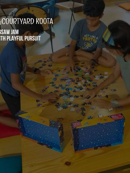 A candid shot of children working on a puzzle at a Jigsaw Jam.