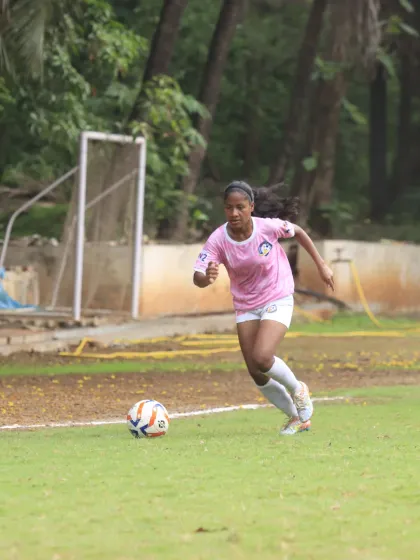 Dribbling down the wing, our player showcases speed and agility in our alternate pink kit.
