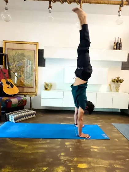 A classic handstand (Adho Mukha Vrksasana). This inversion builds upper body strength, improves balance, and helps to see the world from a new perspective.