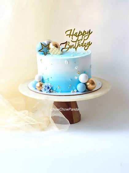 A simple and stylish birthday cake with a blue and white ombre effect. I decorated this Truffle cake with blue, white, and gold spheres for a modern, celebratory look.