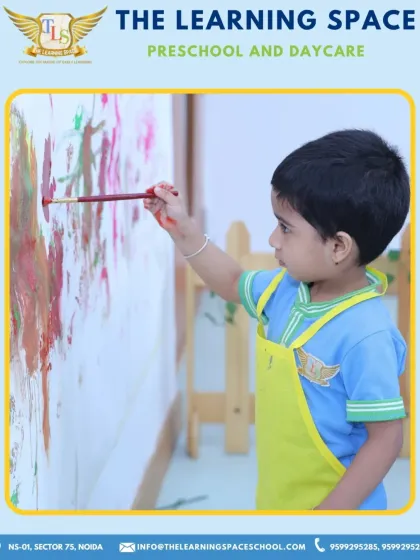 A young artist focuses intently on his masterpiece. We provide large canvases and accessible materials to empower children to think big and express their creativity without limits.