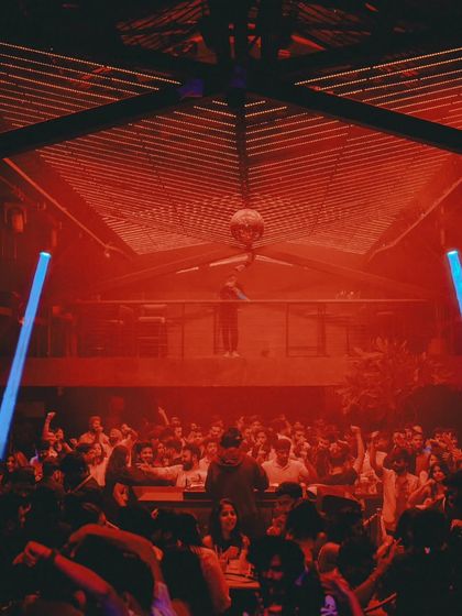 The view from the second floor at Xora, looking down at a sea of people under red lights. An absolutely packed house.