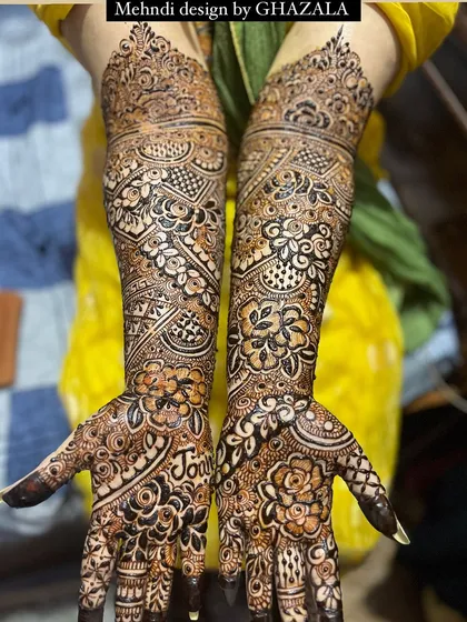 A full view of a bridal design that includes the groom's name, 'Joun', hidden in the palm.