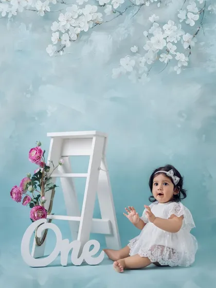 A sweet and gentle moment from her first birthday session. Seated beside the "One" prop, this little girl's expression is priceless. These portraits focus on capturing the innocence of childhood.