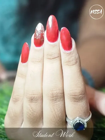 A classic red and silver glitter combination, perfectly executed by a student. This demonstrates their skill in shaping and polish application.