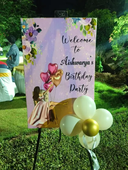 A beautiful, custom-designed welcome sign for Aishwarya's birthday party. This easel sign features floral artwork and personalized text, creating a warm and inviting entrance for guests at this outdoor event.