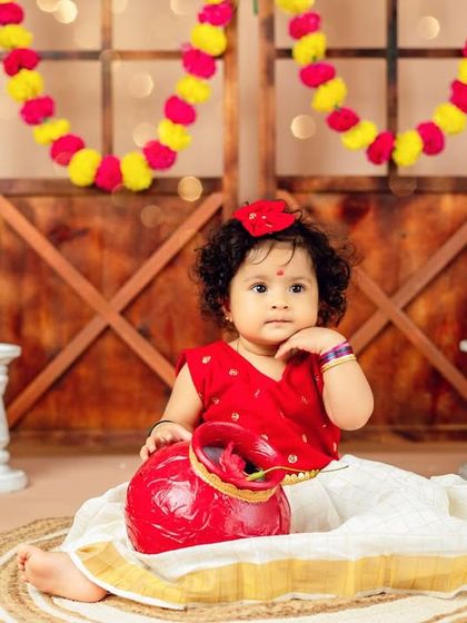 A traditional South Indian theme for this little girl. The vibrant colors of the marigolds and her classic outfit are just beautiful.