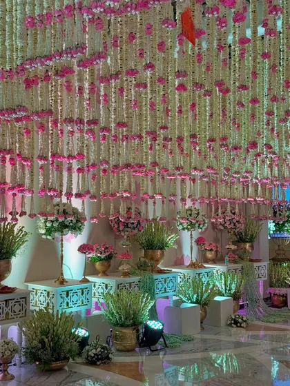 More views of the magical entrance, highlighting the density of the floral ceiling, the elegant decor pieces, and the soft, inviting lighting.