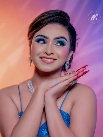 A smiling portrait that captures the glamour of the complete look, from the makeup to the jewellery and gown.