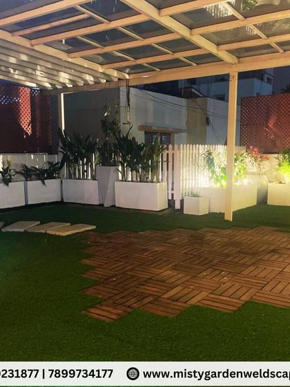 The combination of artificial lawn and WPC deck tiles on this terrace provides different zones for relaxation. The lit planters and PVC lattice screen add privacy and ambiance.