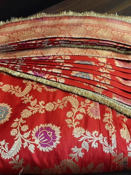 A rich red Banarasi saree, pre-pleated and folded for a bride.