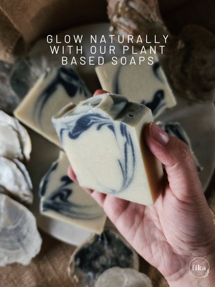 Glow naturally with my plant-based soaps. This bar, held against a backdrop of oyster shells, features a beautiful blue and white swirl reminiscent of the ocean, promising a fresh and clean experience.