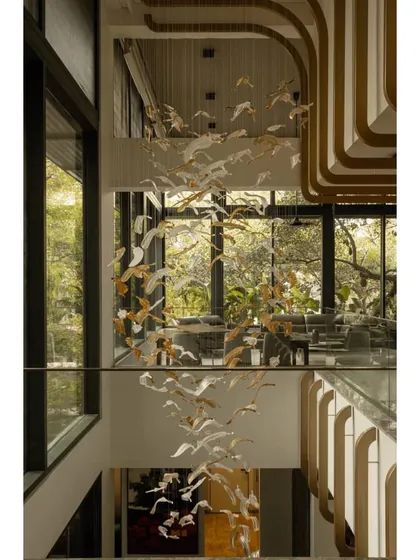 A stunning, custom-designed light fixture featuring a flock of birds cascades through the double-height stairwell of this WAF-nominated home.