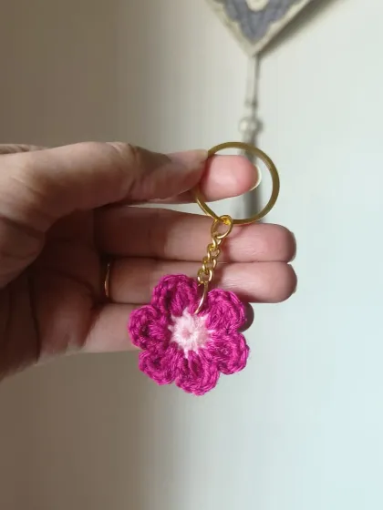 A close up of our magenta floral keychain with a light pink center. The detailed stitching creates a beautiful, multi-layered flower.