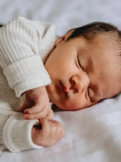 A peaceful close-up of a sleeping newborn. This image focuses on the baby's serene expression and soft features.