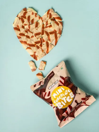 Mini chocolate bites arranged in a heart shape, with the packaging alongside. This simple, creative concept is perfect for themed campaigns like Valentine's Day.